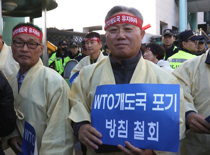 25일 오전 정부서울청사 별관 앞에서 농민단체 회원들이 WTO 개도국 포기 방침 철회를 요구하는 집회를 하고 있다. 연합뉴스