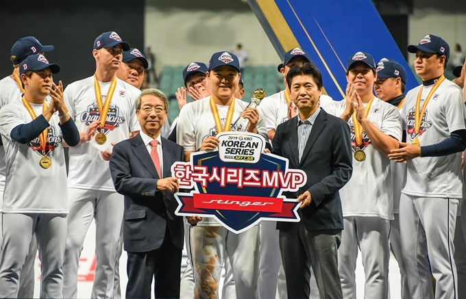 한국시리즈 MVP 오재일 선수(가운데), 정운찬 KBO 총재(왼쪽), 이용민 기아차 국내마케팅실장(상무)이 두산 베어스 선수들과 기념촬영을 하고 있는 모습. 기아자동차 제공