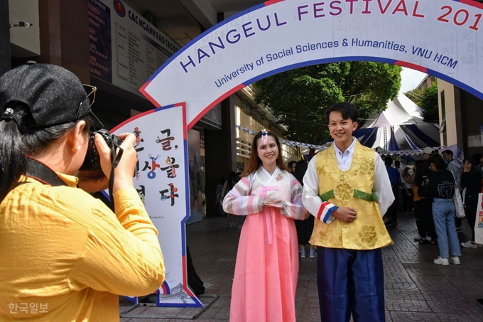 한글 축제 행사장 입구 입간판 앞에서 한복 차림의 학생 커플이 기념사진을 찍고 있다. 한류 드라마 영향으로 한복 입고 사진 찍기는 한국 관련 행사에서 빠지지 않고 등장하는 코너로 매번 큰 인기를 끈다. 쩐이라고 밝힌 남학생은 “조금 덥지만 좋다”고 했다.