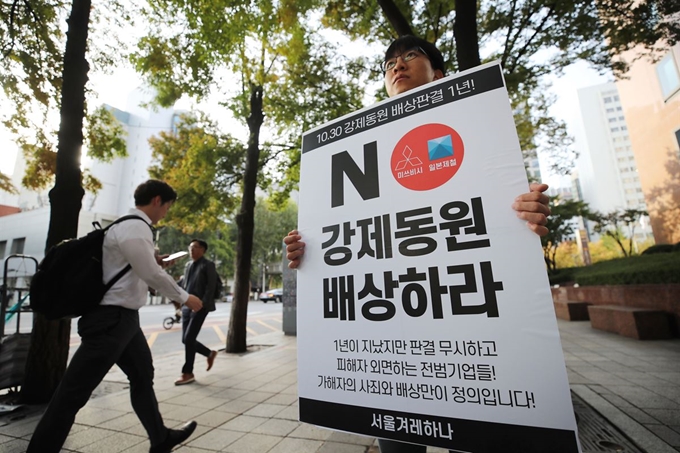 29일 오전 서울 지하철 1호선 종각역 앞에서 서울겨레하나 관계자가 한국인 강제동원 배상 명령한 한국 대법원판결 1주년을 앞두고 전범기업들의 사죄와 배상을 촉구하는 1인 시위를 하고 있다. 연합뉴스