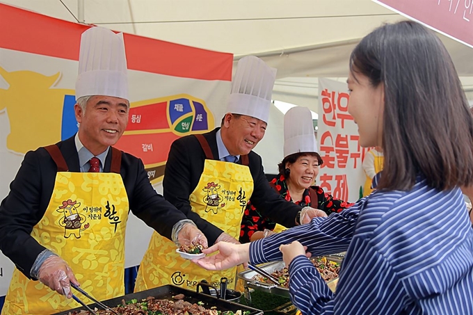 김홍길(왼쪽 1번째) 전국한우협회장과 민경천(2번째) 한우자조금관리위원회 위원장이 지난 4월 경기 과천시 마사회에서 개최한 한우숯불구이축제에서 시식코어에서 한우를 직접 구워 참가자들에게 나눠주고 있다. 전국한우협회 제공