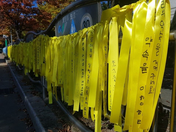 30일 경기 고양시 덕양구 서정초등학교 주변 펜스에 이 학교 아이들과 학부모들이 포스콤을 향해 ‘약속을 지켜주세요’ 등의 내용이 적은 노란색 희망 리본들이 길게 묶여 있다.