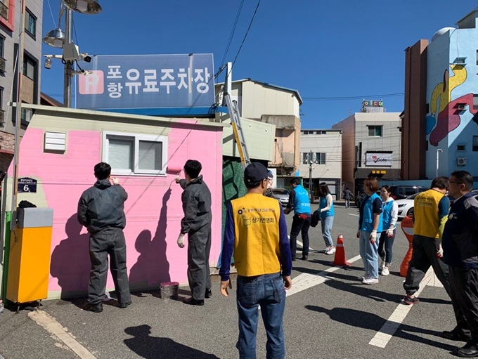 현대제철 경북 포항공장 직원들로 구성된 '온철봉사단' 회원들이 침체된 포항시 북구 여천동의 구도심 도시재생사업에 참여, 낡고 칙칙한 유료주차장 정산소 건물에 페인트 칠을 하고 있다. ㈜문화밥 제공