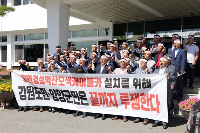 지난달 19일 양양군청 소회의실에서 열린 친환경설악산오색케이블카추진위원회 회의에 참석한 위원들이 환경부의 환경영향평가 부동의로 좌초된 설악산오색케이블카에 대한 후속대책을 논의한 뒤 군청앞에서 성명서를 발표하고 있다. 연합뉴스