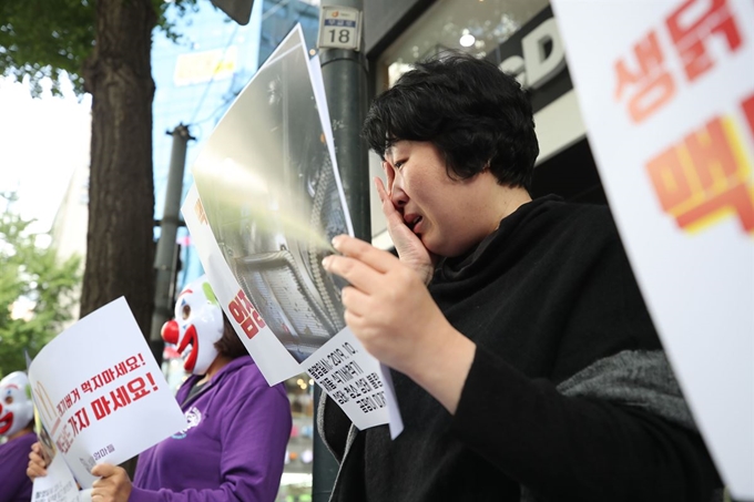 햄버거병 피해아동 어머니 최은주씨가 지난달 29일 서울 중구 맥도날드 서울시청점 앞에서 ‘정치하는엄마들’ 주최로 열린 '한국맥도날드 불매, 퇴출 기자회견'에 참가해 덜 익은 햄버거 패티, 불량제품 등에 대한 검찰 수사 촉구 발언을 한 뒤 눈물을 훔치고 있다. 연합뉴스