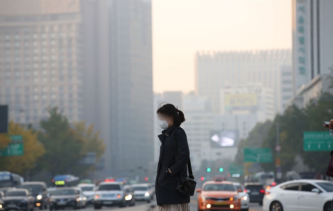 미세먼지 농도가 '나쁨' 수준을 보이는 1일 오전 서울 종로구 광화문 사거리에서 마스크를 쓴 시민이 출근하고 있다. 연합뉴스