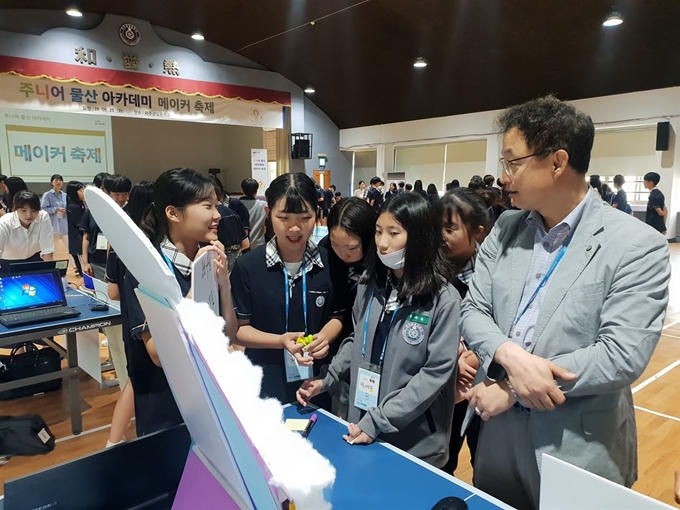 지난 6월 경기 파주 광일중학교에서 열린 삼성물산 ‘주니어 물산 아카데미 메이커 축제’에 참석한 학생들과 임직원들이 함께 한 학기 동안 만든 전시물을 살펴보고 있다. 삼성물산 제공