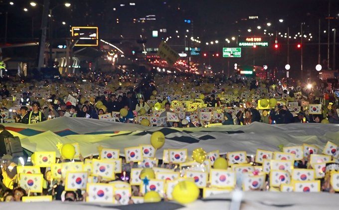 2일 오후 서울 여의도공원 앞에서 열린 '사법적폐청산을 위한 제12차 검찰개혁촛불문화제'에서 참가자들이 태극기 퍼포먼스를 하고 있다. 이날 이들은 공수처 설치, 검찰개혁 법안 통과 등을 촉구했다. 연합뉴스