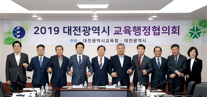 대전시와 대전시교육청이 4일 개최한 대전시교육행정협의회에서 허태정(왼쪽 네번째) 시장과 설동호(왼쪽 다섯번째) 교육감을 비롯한 참가자들이 두 기관간 협조를 다짐하며 손을 맞잡고 있다. 대전교육청 제공