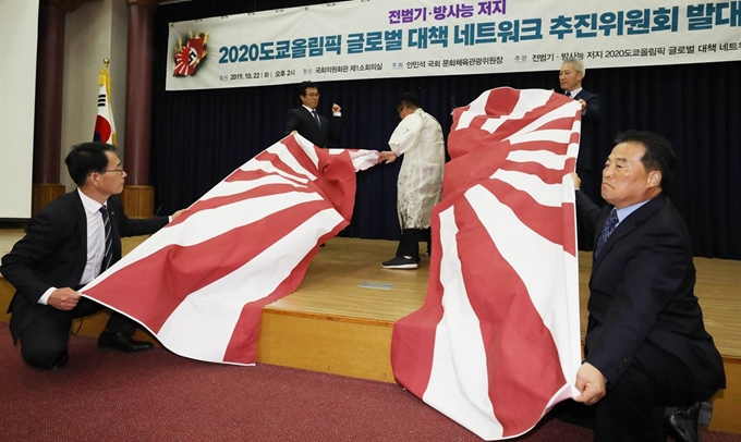 캘리아티스트 권도경 작가가 22일 서울 여의도 국회 의원회관에서 열린 전범기와 방사능 저지 2020도쿄올림픽 글로벌 네트워크 추진위원회 발대식에서 참석해 일본 전범기인 욱일기를 찢는 퍼포먼스를 하고 있다. 뉴시스