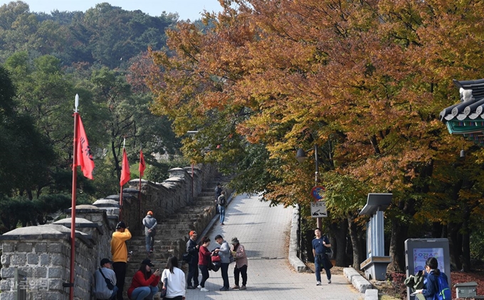 [수7] [저작권 한국일보] 지난 3일 팔달문 쪽 성곽길을 찾은 관광객들이 단풍과 함께 산책하고 있다. 서재훈 기자