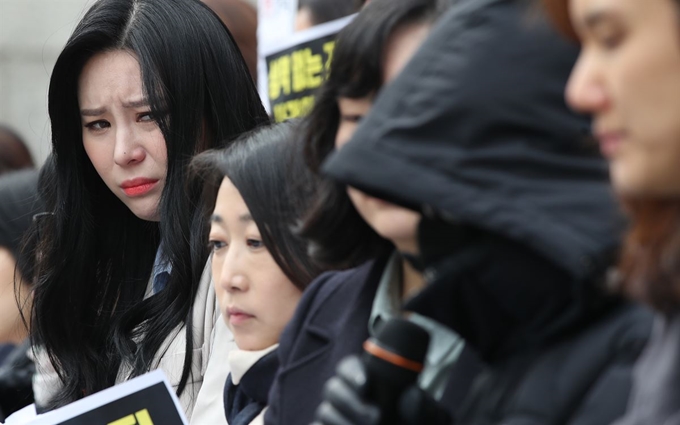 3월 15일 오전 서울 세종문화회관 계단에서 ‘한국여성의전화’ 등 1033개 단체 공동주최로 열린 ‘김학의 전 법무부 차관 등에 의한 성폭력 사건’, ‘고 장자연씨 사건’에 대한 진상규명 촉구 기자회견에서 ‘김 전 차관 성폭력 사건’ 피해자가 증언하고 있다. 앞서 증언한 윤지오씨가 증언을 들으며 괴로워하고 있다. 연합뉴스