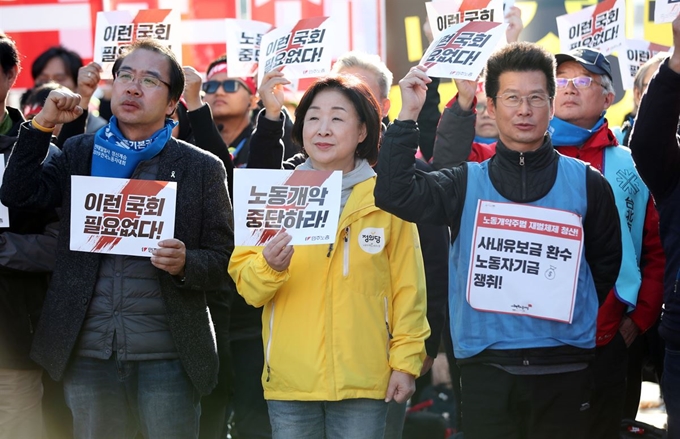 정의당 심상정 대표(가운데)가 9일 오후 서울 영등포구 여의도 마포대교 남단 여의대로에서 열린 전태일 열사 정신 계승 전국노동자대회에서 손팻말을 들고 있다. 연합뉴스