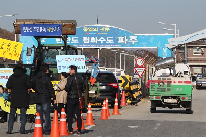 경기도 파주 지역 민간인통제선(민통선) 마을 주민들이 8일 통일대교 남단에서 아프리카돼지열병(ASF) 관련 통제 해제를 촉구하는 집회를 진행 중인 가운데 방역차량이 민통선으로 진입하고 있다. 연합뉴스