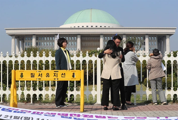 이정미(맨 왼쪽) 정의당 의원이 지난달 21일 국회 정문 앞에서 어린이생명안전법안 통과 촉구 기자회견을 마친 뒤 발걸음을 떼지 못한 채 눈물을 흘리는 하준이와 태호, 민식이 엄마 아빠를 말없이 바라보고 있다. 연합뉴스