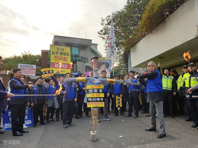 5ㆍ18 관련 단체 회원들이 12일 서울 연희동 전두환 전 대통령 자택 앞에서 화형식 퍼포먼스를 하고 있다. 조소진 기자