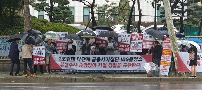 지난달 7일 서울남부지검 앞에서 IDS홀딩스 사기사건 피해자들이 비가 오는 가운데 집회를 열고 검찰의 부실수사를 규탄하고 있다. 강철원 기자