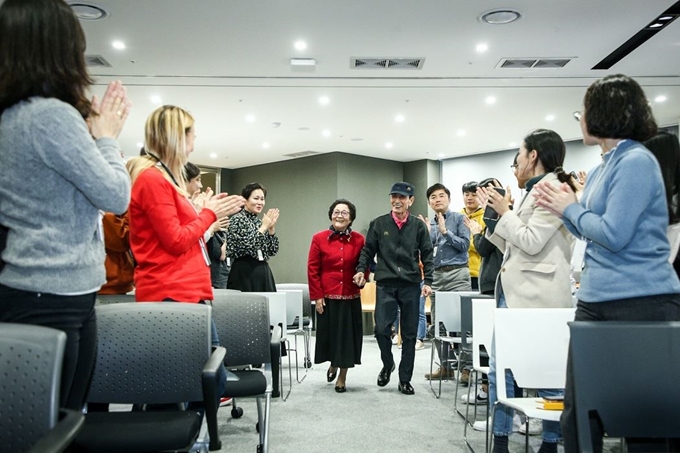 지난 8일 서울 종로구 한국맥도날드 본사에서 최고령 직원 임갑지(오른쪽)씨가 아내 최정례씨와 함께 임직원들의 박수를 받으며 은퇴식을 위해 입장하고 있다. 한국맥도날드 제공