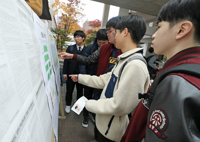 수능을 하루 앞둔 13일 서울 종로구 경복고에서 수험생들이 시험실 배치도 및 주의사항을 살펴보고 있다. 연합뉴스