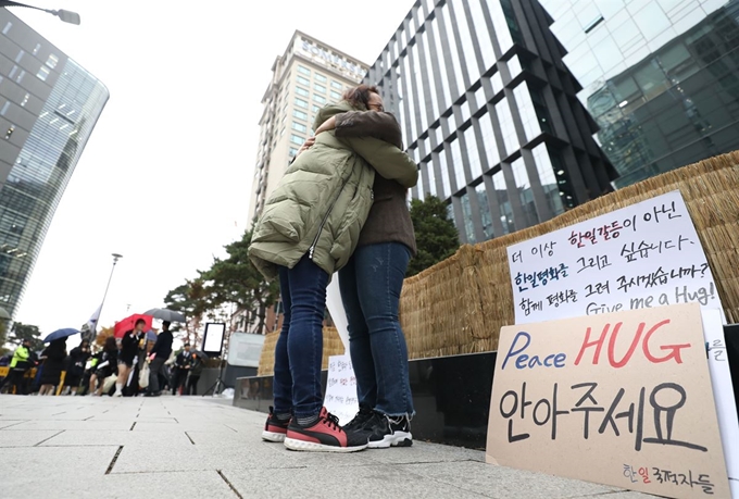 13일 오후 서울 종로구 구 일본대사관 인근에서 한 '한일국적자들' 소속 회원이 한 시민과 프리허그를 하고 있다. 뉴시스