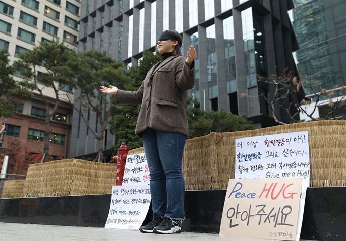 13일 오후 서울 종로구 구 일본대사관 인근에서 한 '한일국적자들' 소속 회원이프리허그를 하고 있다. 뉴시스