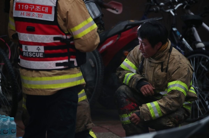 15일 오후 서울 서초구 진흥종합상가에서 발생한 화재를 진압한 소방관이 휴식을 취하고 있다. 지하 1층에서 발생한 화재로 인해 소방관을 포함한 12명이 다치고 지하층 내부와 자재 등을 태웠다. 연합뉴스