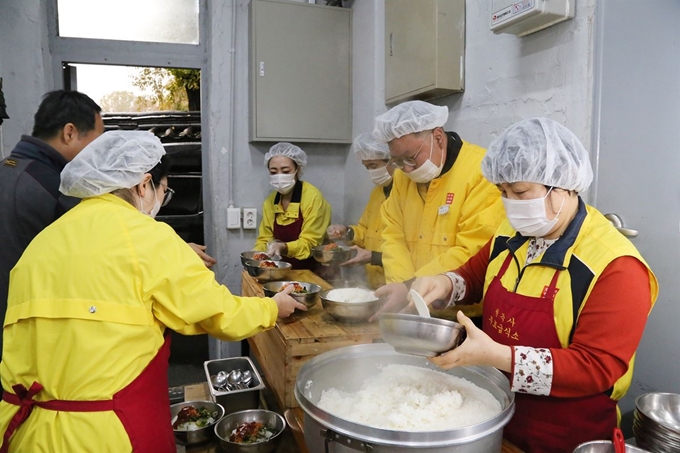 (주)아성다이소 임직원들이 지난 15일(금) 서울 종로구 탑골공원 옆 사회복지원각 무료급식소를 찾은 취약계층 시민들에게 배식봉사를 하고 있다. 아성다이소 사진제공