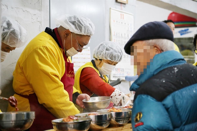 (주)아성다이소 임직원들이 지난 15일(금) 서울 종로구 탑골공원 옆 사회복지원각 무료급식소를 찾은 취약계층 시민들에게 배식봉사를 하고 있다. 아성다이소 사진제공