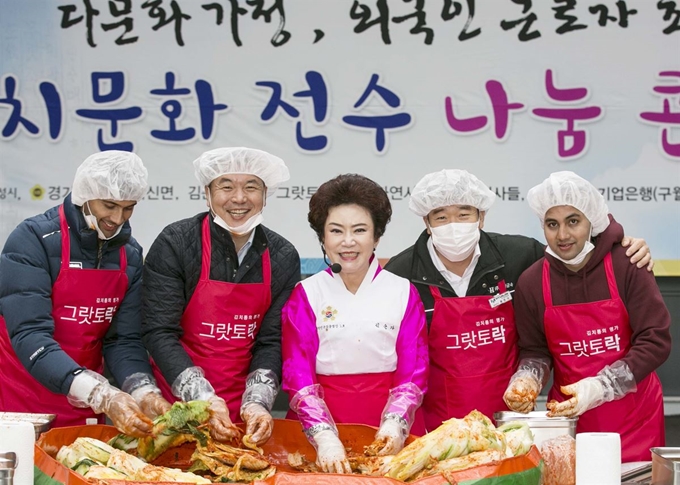 지난 16일 경기 화성시 ㈜현진금속에서 열린 '김치문화 전수 나눔 콘서트'에서 김순자 김치명장(가운데)과 외국인 근로자 등이 김장을 담그고 있다. 왼쪽부터 네팔노동자 뻐러디뻐씨, 김수복 그랏토락 대표, 그랏토락 대표, 김 명장, 홍종국 현진금속 대표, 네팔 노동자 수레서씨. 현진금속 제공