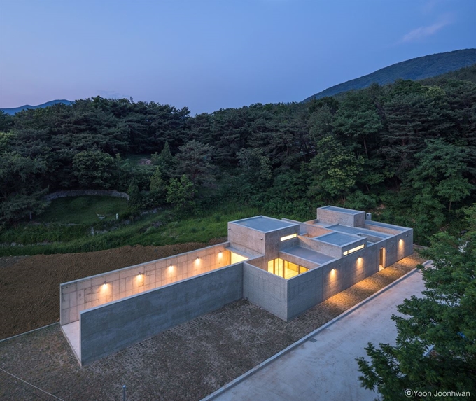 울산 울주군 두동면에 낮게 자리한 ‘닫힌 집 열린 집’은 외부에서 보면 내부를 전혀 가늠할 수 없다. 길이가 40m로 긴 직사각형의 집의 서쪽에는 벙커를 연상시키는 18m 상당의 벽이 서로 마주하고 있다. ©윤준환 건축사진작가