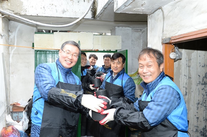 우중본(왼쪽) 대성에너지 대표이사와 임직원들이 18일 대구 중구 남산동 가정에 후원하는 연탄을 옮기고 있다. 대성에너지 제공