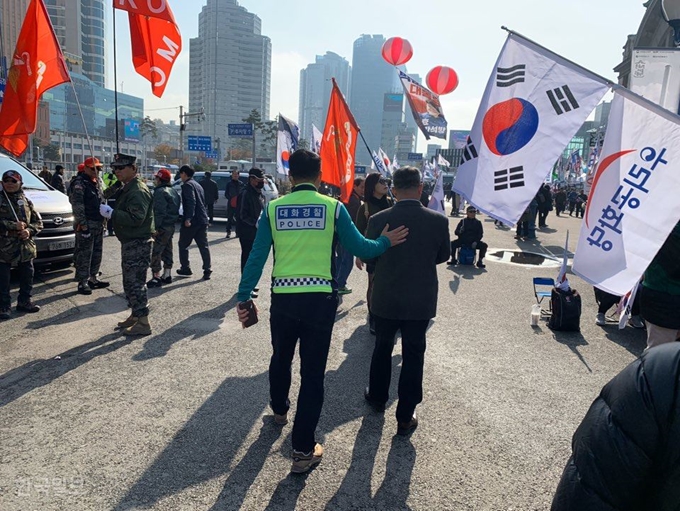 [저작권 한국일보] 서울역 앞에서 보수단체 태극기 집회가 열린 지난 16일 서울 남대문경찰서 ‘대화경찰’ 최종득 경위가 노숙인과 시비가 붙은 집회 참가자를 설득해 떼어놓고 있다. 김영훈 기자