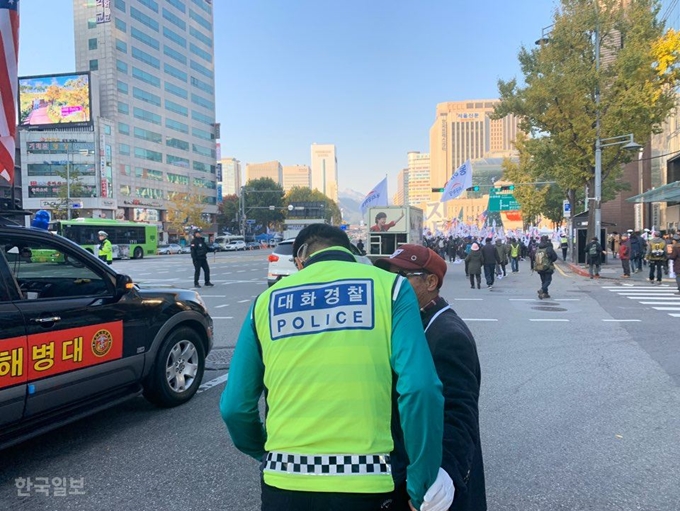 [저작권 한국일보] 서울역 앞 보수단체 태극기 집회가 열린 지난 16일 대화 경찰 최종득 경위가 시위대 행렬을 너무 자주 끊지 말라는 불만을 듣고 있다. 김영훈 기자