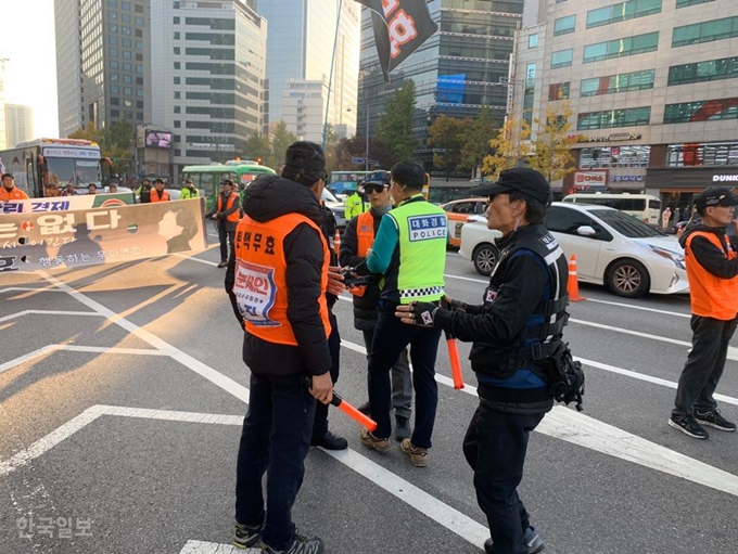 [저작권 한국일보] 서울역 앞에서 보수단체 태극기 집회가 열린 지난 16일 최종득 경위가 얼른 달려가 집회 참가자들 사이에서 벌어진 싸움을 중재하고 있다. 김영훈 기자/2019-11-20(한국일보)