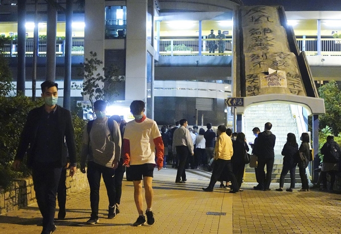 홍콩 이공대에 고립됐던 미성년 학생들이 19일 새벽 학교 교장 선생님의 인도하에 포위망 밖으로 나서고 있다. 홍콩=AP 연합뉴스