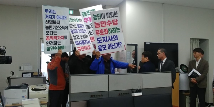 충북도내 농민단체들이 19일 충북도의 ‘농가 기본소득보장제’도입 발표 회견장을 찾아 피켓을 들고 거세게 항의하고 있다. 한덕동 기자