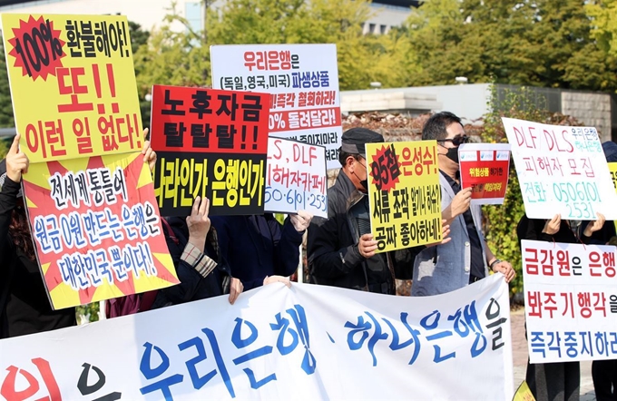 지난달 21일 서울 여의도 국회 앞에서 열린 '우리·하나은행 해외금리 연계 파생결합상품(DLF·DLS) 판매 관련 철저한 조사 촉구 기자회견'에서 피해자들이 구호를 외치고 있다. 연합뉴스