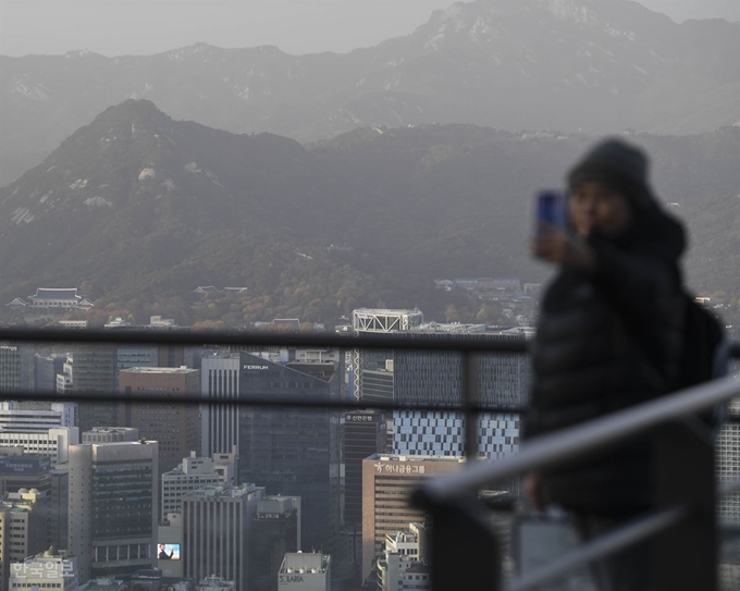 18일 오후 서울 용산구 남산서울타워에서 외국인 관광객이 미세먼지 가득한 서울 도심을 배경으로 기념사진을 찍고 있다. 박형기 인턴기자