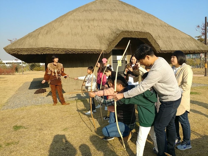 시흥 선사유적공원을 찾은 관광객들이 신석기시대 사용했던 목궁 쏘기 체험을 하고 있다. 시흥시 제공