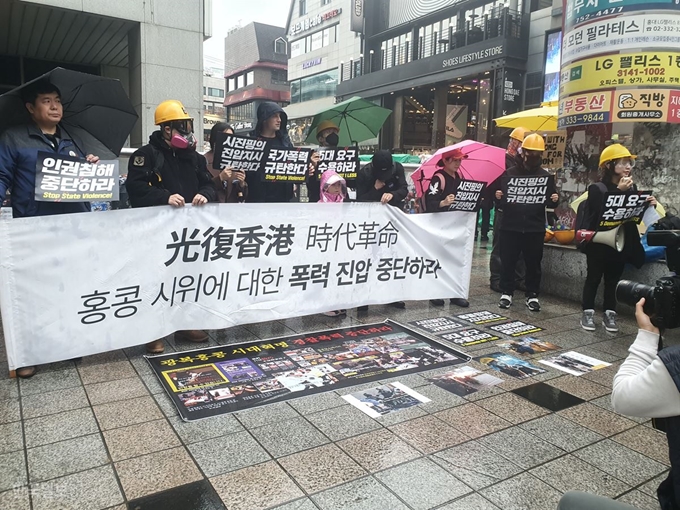 [저작권 한국일보] ‘홍콩의 민주화 운동에 함께하는 한국 시민모임’ 소속 시민들이 24일 오후 2시쯤 서울지하철 홍대입구역 9번출구 앞에서 홍콩 시위 폭력 진압 중단을 요구하는 현수막을 들고 홍콩 시위대 연대 집회를 열고 있다. 최은서 기자