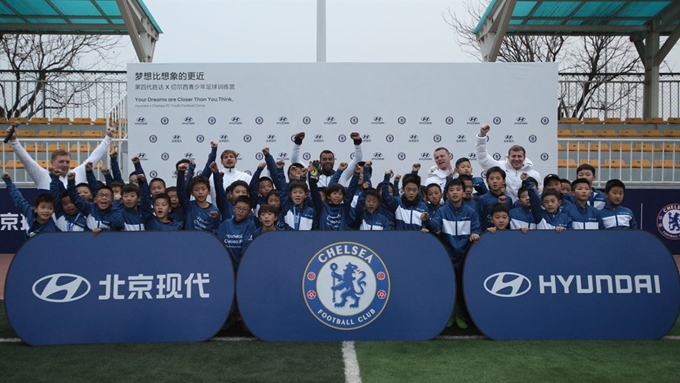 첼시 FC 레전드 애슐리 콜 선수와 첼시 아카데미 코치진이 축구 캠프에 참가한 아이들과 함께 기념 촬영을 하고 있는 모습. 현대자동차 제공