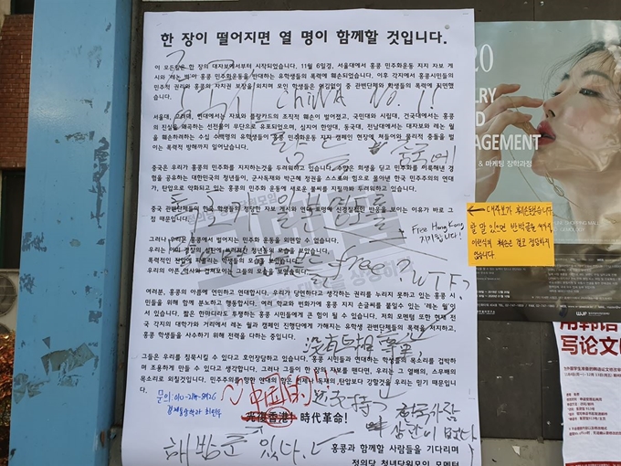 지난 19일 서울 광진구 세종대 군자관 앞에 게시된 홍콩 시위 지지 대자보에 중국인 유학생이 한 것으로 보이는 낙서가 남아있다. 최은서 기자