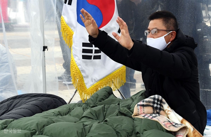 단식 중인 황교안 자유한국당 대표가 24일 청와대 앞 분수대 광장에 설치한 비닐 천막 안에서 지지자들에게 손을 흔들고 있다. 배우한 기자