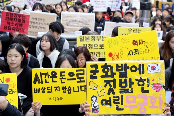 지난 6일 서울 종로구 옛 주한 일본대사관 앞에서 정의기억연대 주최로 열린 일본군 성노예제 문제해결을 위한 제1412차 정기수요집회에 참석한 시민들이 손피켓을 들고 있다. 정의기억연대는 일본의 사과 없이 배상금만 받아서는 역사적 문제가 해결되지 않는다고 주장하고 있다. 뉴시스