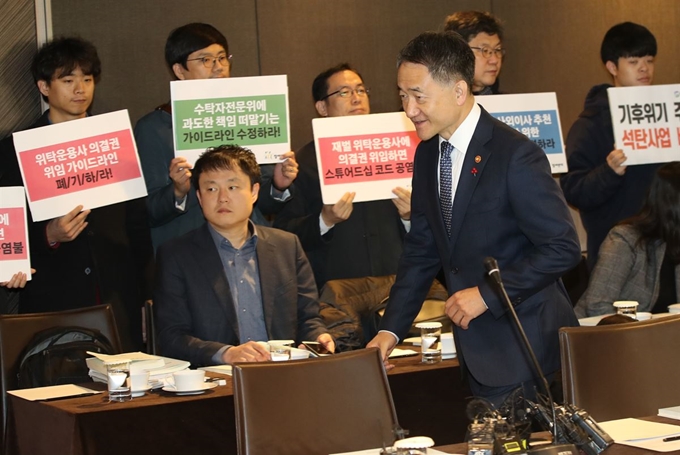 박능후 보건복지부 장관이 29일 오전 서울 중구 더플라자호텔에서 열린 제8차 국민연금 기금운용위원회 회의를 주재하기 위해 회의장으로 들어서고 있다. 뒤편에서는 참여연대 경제금융센터 관계자 등이 ‘수탁자책임에 관한 원칙(스튜어드십 코드)’ 가이드라인 재논의를 촉구하는 피켓을 들고 있다. 연합뉴스