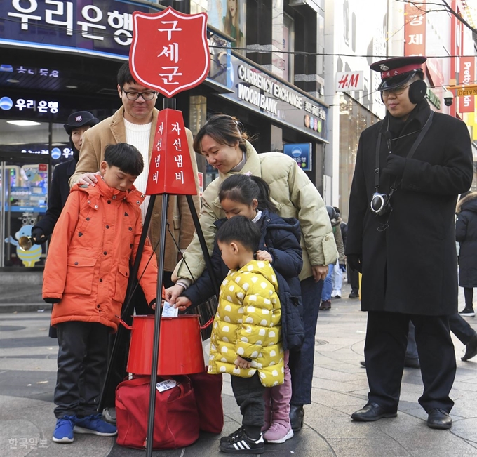 구세군 자선냄비 모금활동이 시작된 29일 서울 중구 명동 번화가에서 시민들이 자선냄비에 성금을 넣고 있다. 박형기 인턴기자