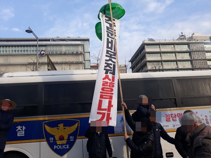 30일 전농 회원들이 서울 종로구 주한 미국대사관 앞에서 '주둔비 못 줘 싫음 나가'라고 쓰인 현수막이 담긴 박을 들고 있다. 손성원 기자