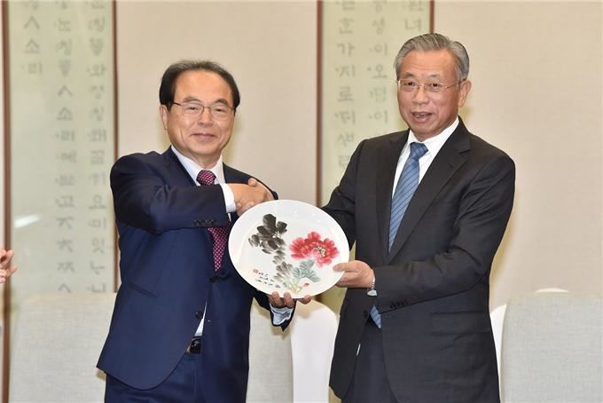 오거돈 부산시장과 리우자이 중국 산둥성 당서기가 1일 환담을 마치고 기념 선물을 교환하며 악수를 하고 있다. 부산시 제공