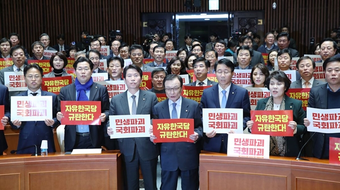 더불어민주당 이해찬 대표와 이인영 원내대표 등 의원들이 2일 오후 서울 여의도 국회에서 열린 의원총회에서 자유한국당 규탄 손팻말을 들고 있다. 연합뉴스