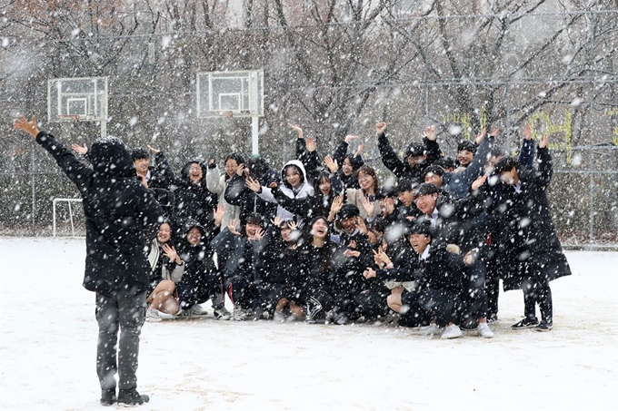 경기도 일부 지역에 눈이 내린 3일 오전 경기도 군포시 산본고등학교에서 학생들이 내리는 눈을 맞으며 추억을 남기고 있다. 뉴스1